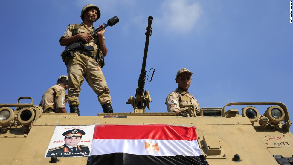 Egyptian soldiers stand guard atop an armored vehicle on a bridge leading to Cairo&#39;s Tahrir Square on Friday, July 26.