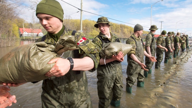 Canadian forces soldiers lay down sandbags to reinforce the highway in Saint-Andre-d'Argenteuil, Que., west of Montreal.