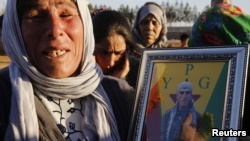 A Kurdish refugee in the Turkish town of Suruc holds a picture of her son, Merwan Imam, a YPG fighter whose body was not recovered in the battle for Kobani against Islamic State militants.