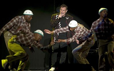 In this photo taken Saturday, July 2017, South African musician Johnny Clegg, middle, and the dancers perform during "The Final Journey" concert at the Grand Arena in Cape Town, South Africa. (AP Photo)