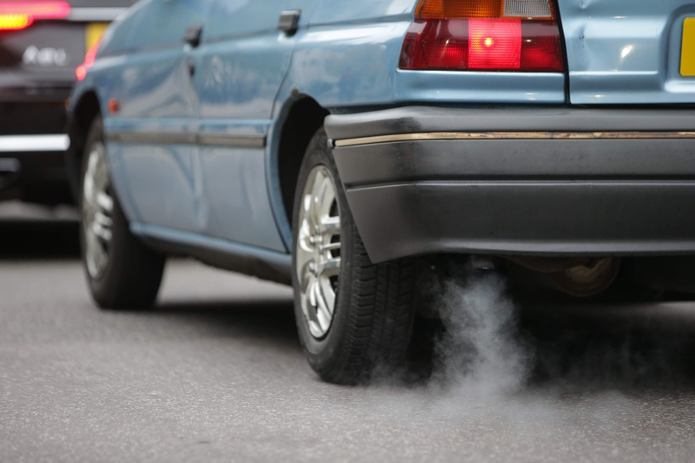A car emits fumes from its exhaust as it waits in traffic in central London, England on Monday.  Drivers of the most polluting vehicles will face an extra daily charge for driving into central London on weekdays from Monday in a bid to improve air quality in one of Europe's most polluted cities. — AFP