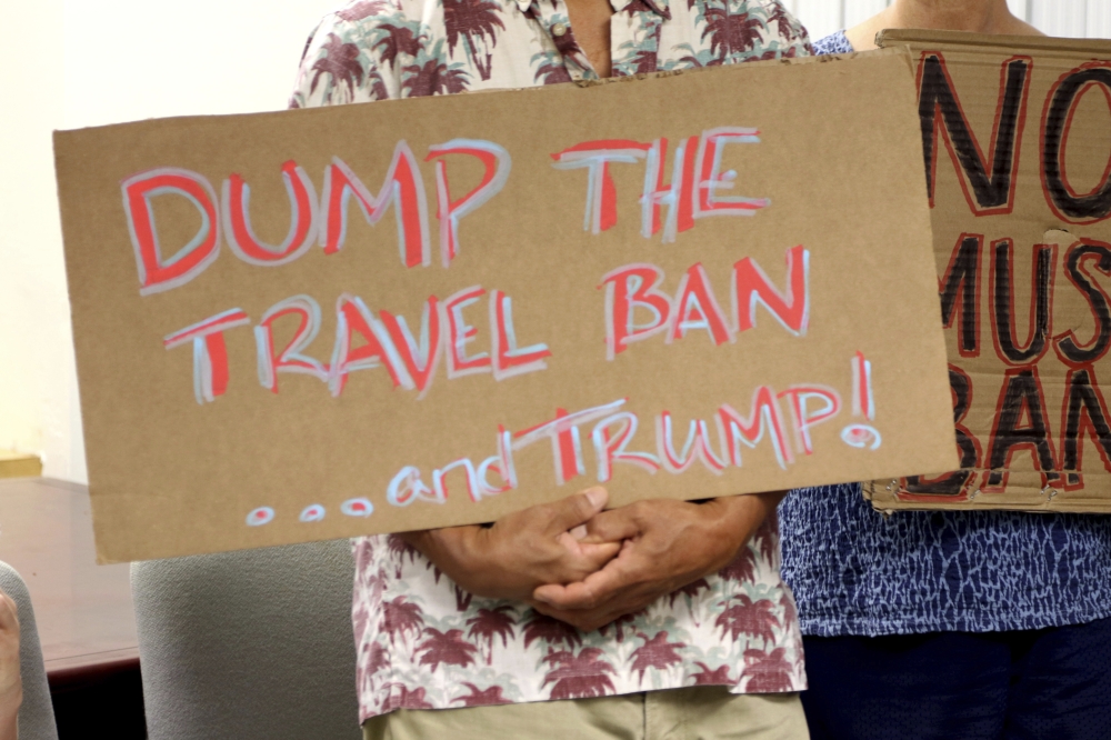 In this June file photo, critics of President Donald Trump's travel ban hold signs during a news conference in Honolulu. The Trump administration is appealing a Hawaii judge's order that blocks the newest version of the travel ban. Attorneys for the U.S. government filed court papers Tuesday,saying they are taking the case to the 9th U.S. Circuit Court of Appeals. The appeals court has blocked both of Trump's previous bans. — AP