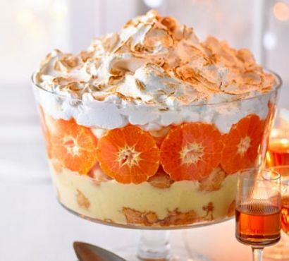 Eggnog trifle with rows of orange segments and meringue topping