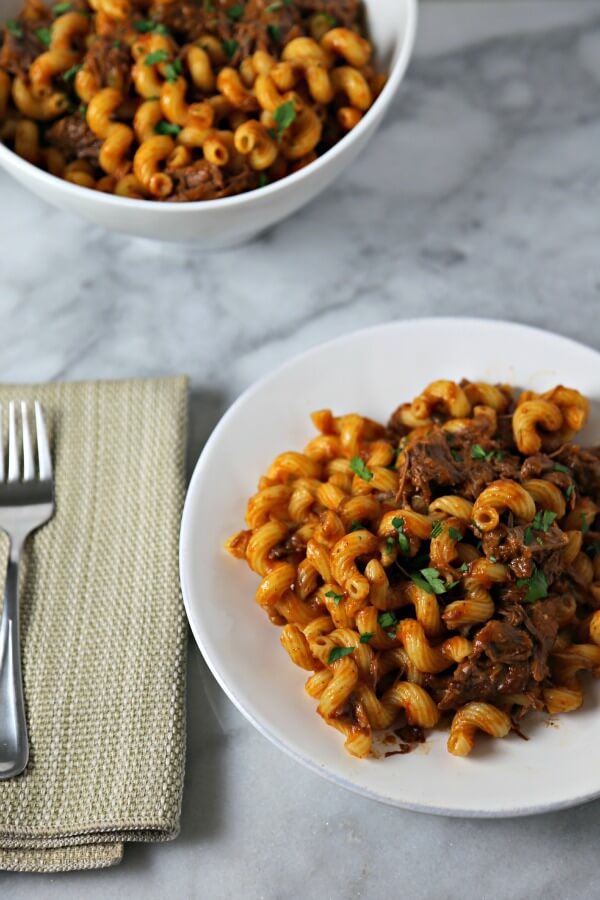 Pasta with Braised Short Ribs from CookingInStilettos.com is perfect for entertaining or Sunday supper. Braised Short Ribs are simmered in a rich flavorful tomato sauce and tossed with cavatappi pasta for a chic and comforting dinner. | Short Ribs | Short Rib Pasta | Pasta Recipes | Short Ribs in Tomato Sauce | Oven Braised Short Ribs
