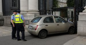  Gardaí at the scene of a collision where a car crashed into the gates of Government Buildings in Dublin. Photograph: Collins