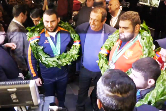 World Champ Simon Martirosyan (left) with his teammates and Armenia's National Olympics Chair Gagig Tsarukian at Zvartnots Airport on Monday