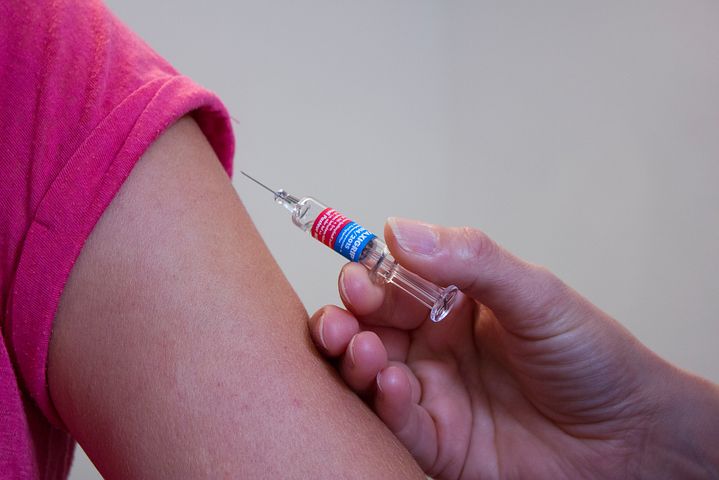 woman in pink getting a flu vaccine