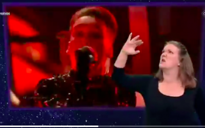 Matthías Tryggvi Haraldsson, of Iceland's Hatari, sings at the May 18 finale of Eurovision 2019, while a sign language interpreter gives a spirited translation of his vocals. (Courtesy Twitter screen grab)