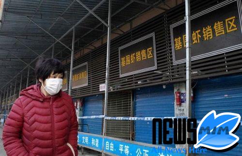 A lady in Wuhan, China, in front of a seafood marketplace where a conflict is suspicion to have begun.