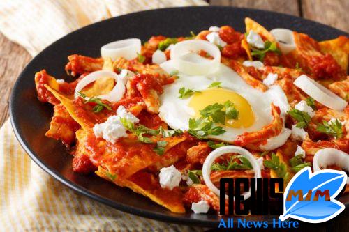 Tortillas with tomato salsa, chicken and egg close-up on a plate.nbsp;