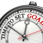 time to set goals concept clock closeup isolated on white background with red and black words