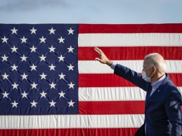 Joe Biden gives a speech by a flag. 