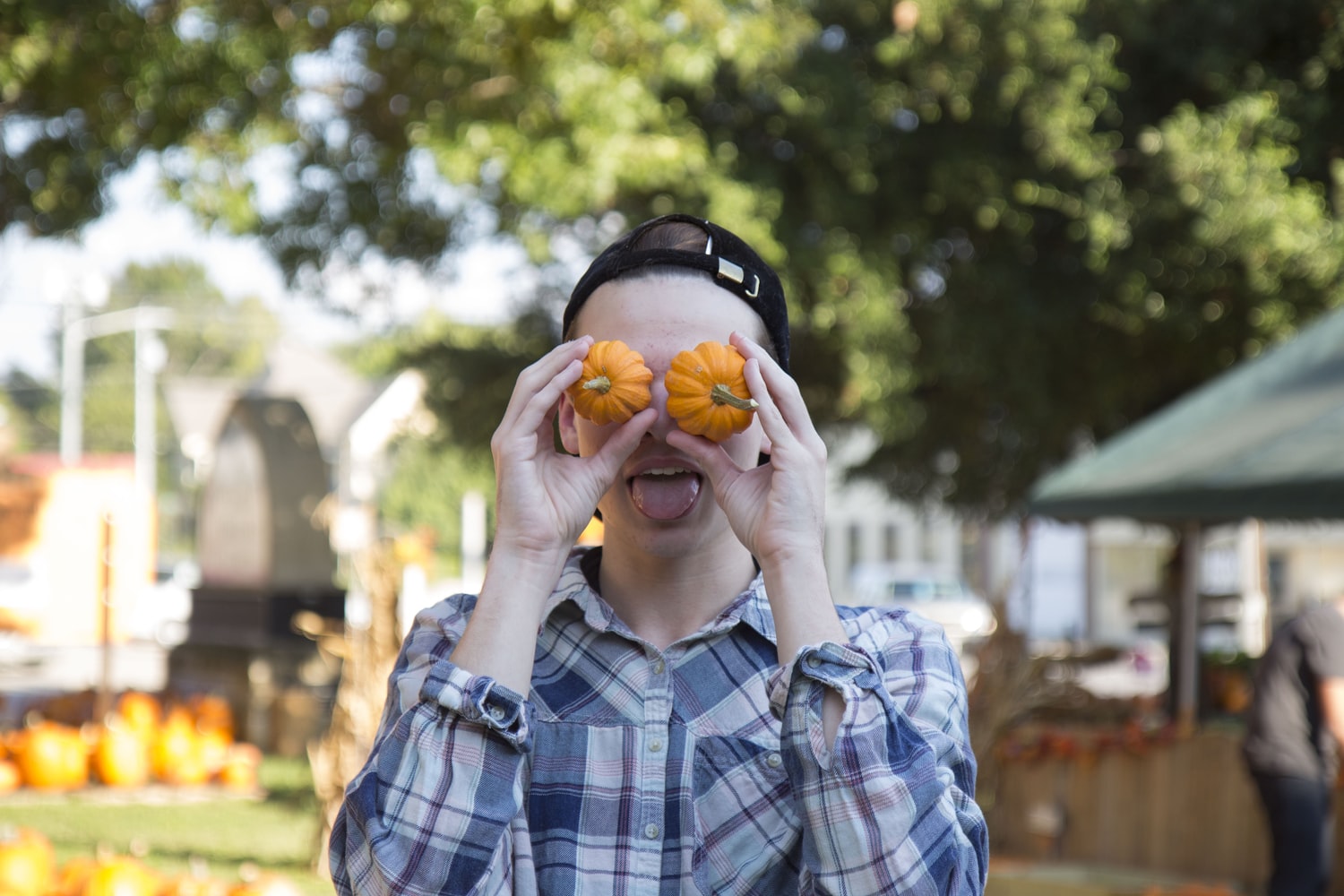 boy with two small pumpkins in his eyes