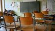 Stühle sind in einem Klassenzimmer hochgestellt.