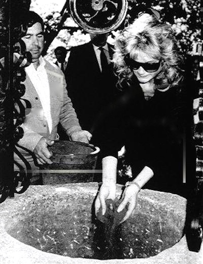 Orson Welles’ daughter Beatrice puts bullring sand down a dry well on his ranch in Ronda, southern Spain, Thursday, May 7, 1987, on top of Welles’ ashes. His friend, ex-bullfighter Antonio Ordonez, hold a bucket with more sand.