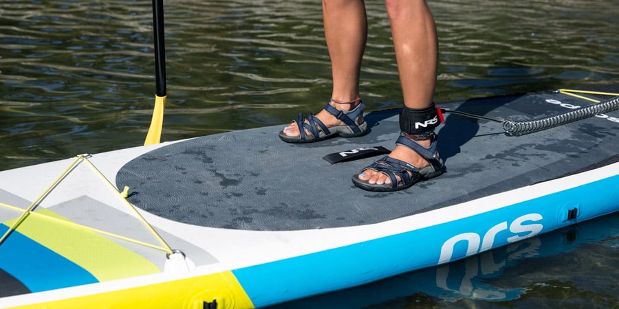 a stand up paddle boarder's stance for maintaining balance while on the board