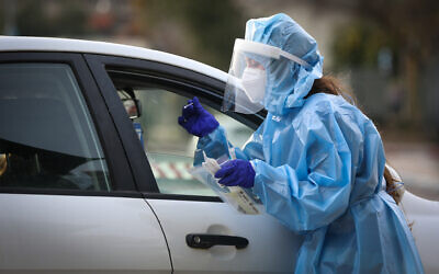 A medical worker collects samples for coronavirus testing in Safed, on February 8, 2021 (David Cohen/Flash90)