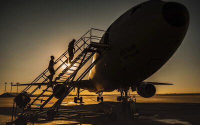 Two KC-10 Extender crew chiefs board the aircraft at Al-Dhafra Air Base, United Arab Emirates, January 5, 2021. (US Air Force/Staff Sgt. Trevor T. McBride, via AP)