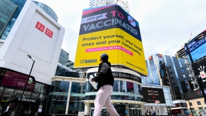 A man looks up at an electronic COVID-19 vaccination sign at Dundas Square during the COVID-19 pandemic in Toronto on Tuesday, May 11, 2021. THE CANADIAN PRESS/Nathan Denette