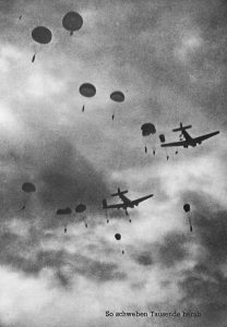 Paratroopers and aeroplanes in the sky above Crete during airborne invasion - Courtesy of The Alexander Turnbull Library