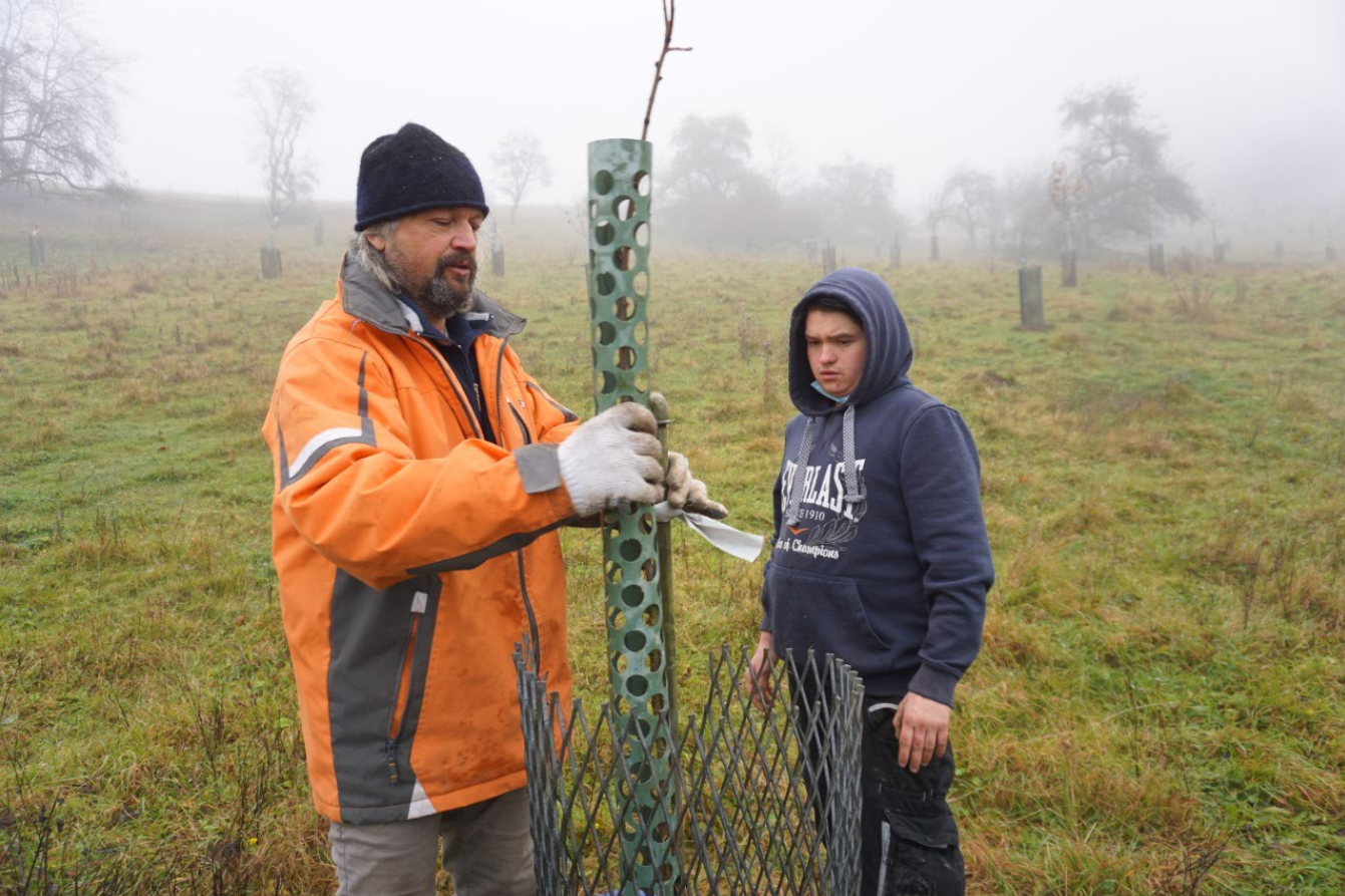Landwirt Thomas Degenhardt und Schüler Lucas Liedel bei der Pflanzung eines Baumes