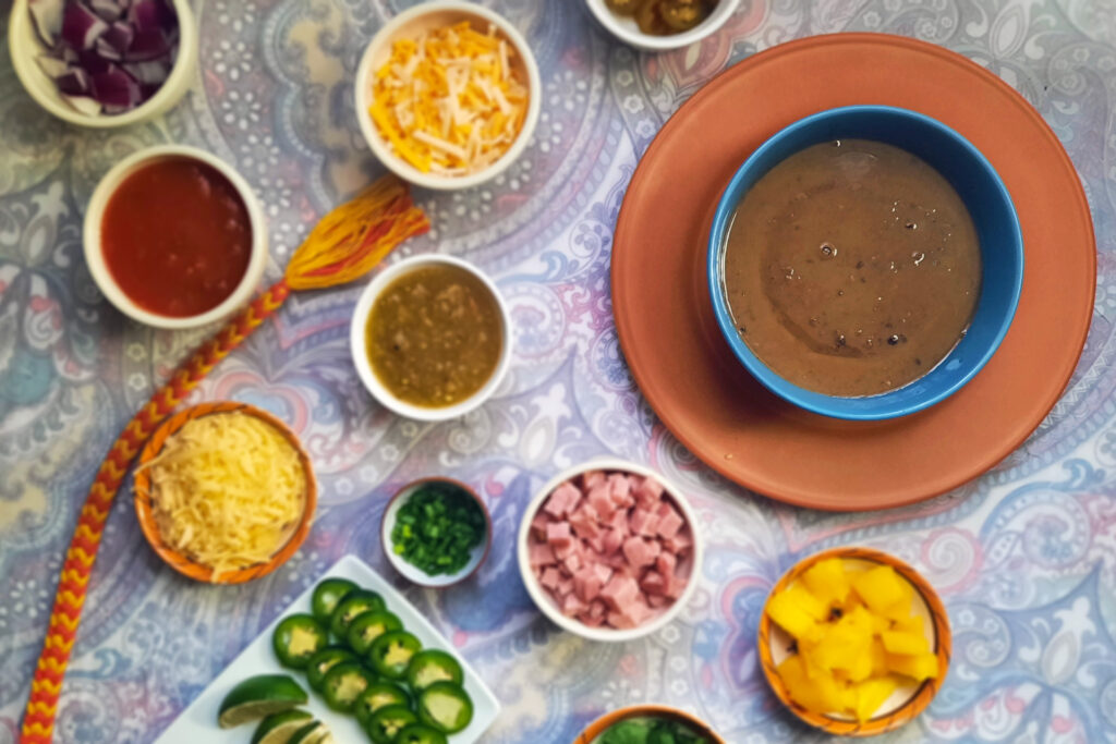 toppings-scattered-around-blue-bowl-of-Loaded-Jerk-Spiced-Black-Bean-Soup