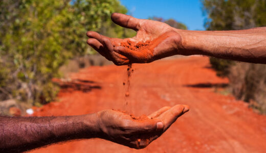 Red earth passing through hands