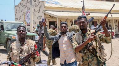 Sudanese army soldiers, loyal to army chief Abdel Fattah al-Burhan, pose for a picture at the Rapid Support Forces (RSF) base in the Red Sea city of Port Sudan, 16 April 2023