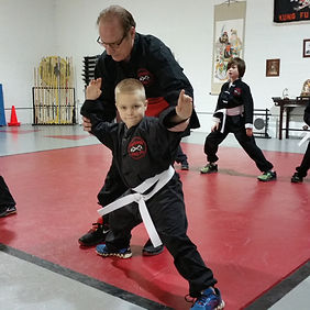 Teaching child in white belt kung fu